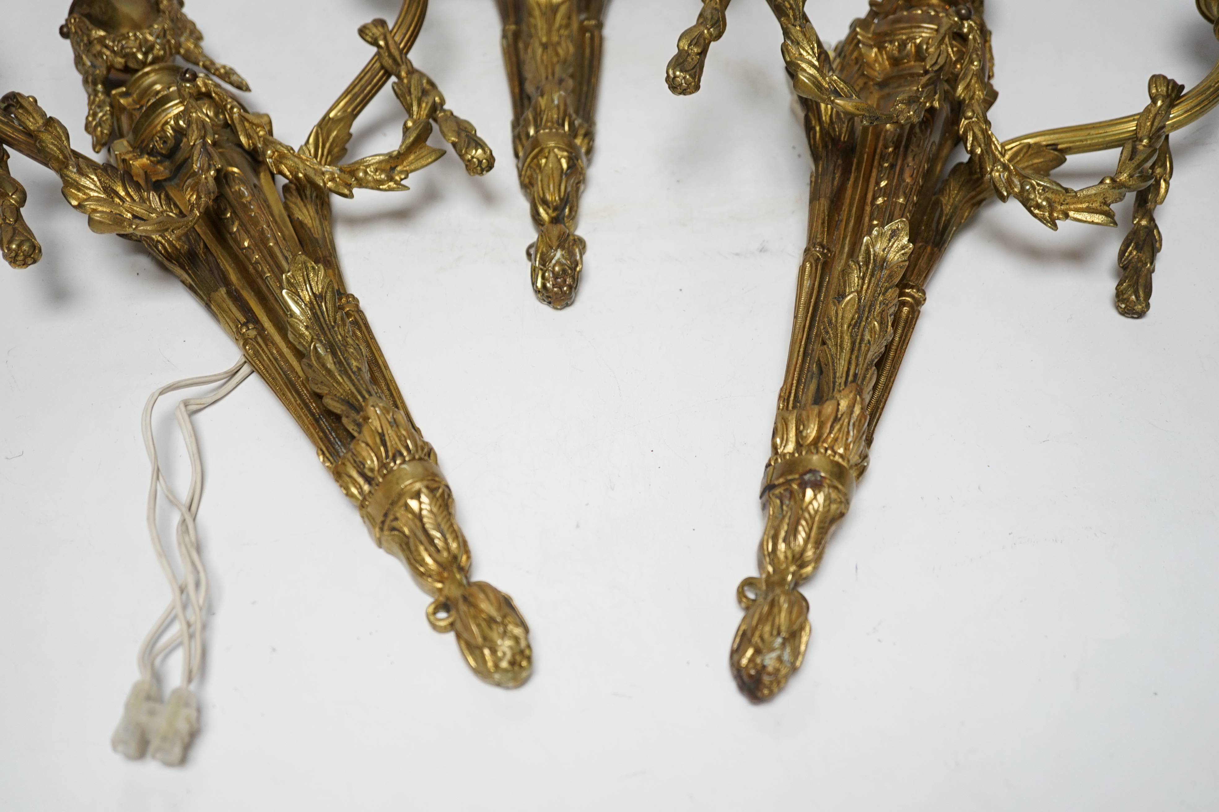A set of three Louis XVI style two branch ormolu wall lights, 38cm high